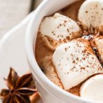 a white mug with hot chocolate and marshmallows on top