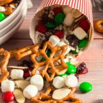 a red and white striped cup on its side with trail mix