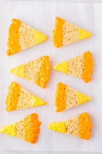 rice krispies cut into triangled and the ends are dipped in chocolate